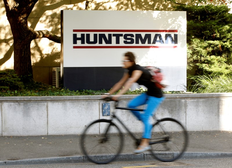 © Reuters. FILE PHOTO: A woman cycles past the logo of U.S. chemical company Huntsman in front of a plant in Basel