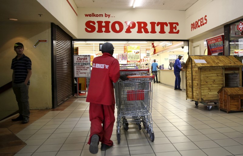 © Reuters. FILE PHOTO: A worker pushes trolleys at the Shoprite store in Johannesburg, South Africa
