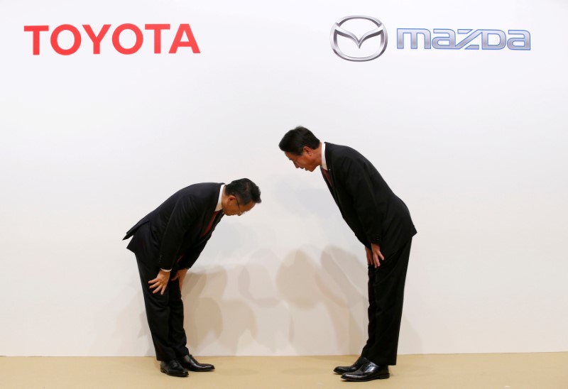 © Reuters. FILE PHOTO: Toyota Motor President Akio Toyoda and Mazda Motor President Masamichi Kogai bow at a joint news conference in Tokyo