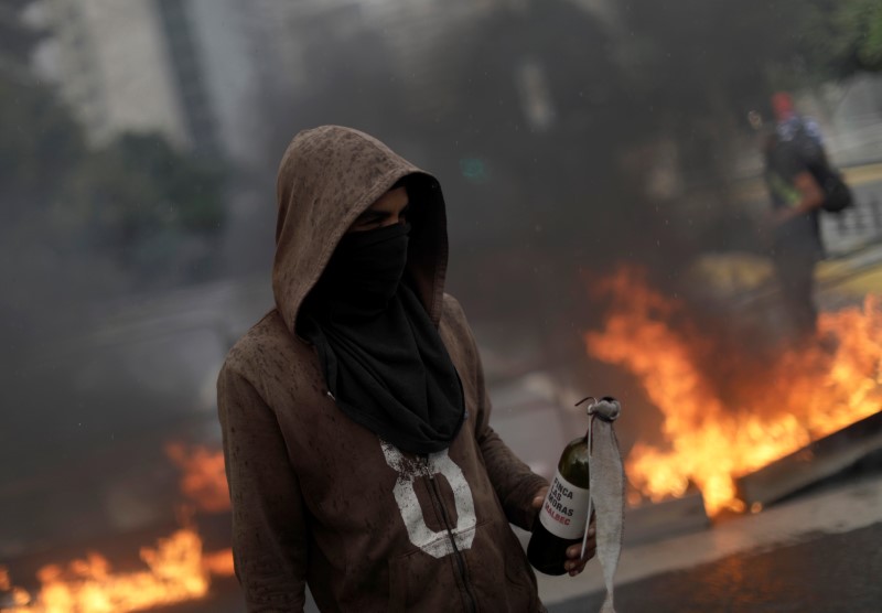 © Reuters. Demonstrators build fire barricades while rallying against Venezuela's President Nicolas Maduro's government in Caracas