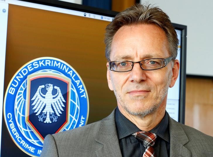 © Reuters. Holger Muench, Chief Commissioner of Germany's Bundeskriminalamt (BKA) Federal Crime Office poses next to a logo of the BKA Cybercrime Intelligence Unit in Wiesbaden