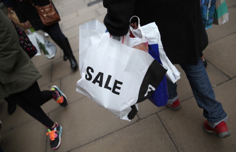 © Reuters. A shopper carries a bag advertising a sale on Oxford Street in London, Britain