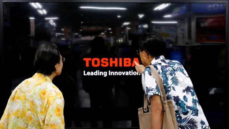 © Reuters. FILE PHOTO: Shoppers look at Toshiba Corp's Regza television at an electronics store in Yokohama