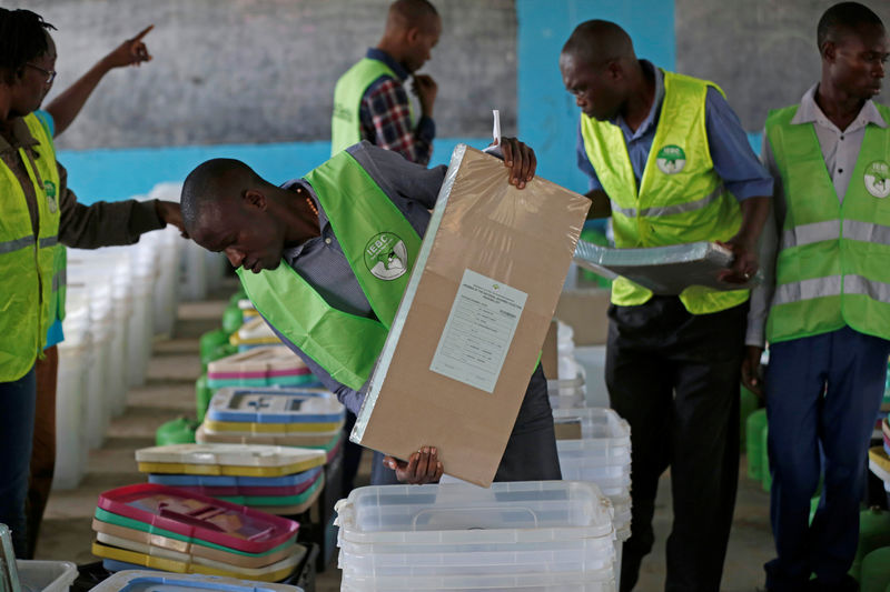 © Reuters. Election officials from the IEBC arrange ballot boxes and election material at a holding center before distribution to polling centers, in Nairobi