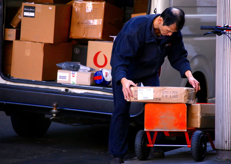 © Reuters. A worker places parcels from his van onto a trolley for delivery in the central business dictrict of Sydney, Australia