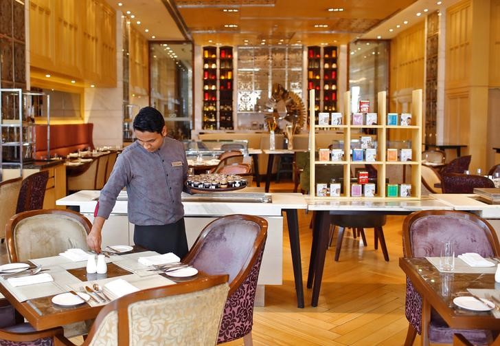 © Reuters. An employee sets a table inside a restaurant at the Crown Plaza hotel, run by IHG, in New Delhi