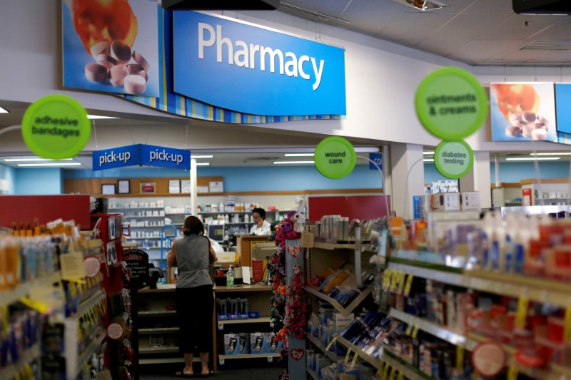 © Reuters. FILE PHOTO -  A customer waits at the counter of a CVS Pharmacy store in Pasadena