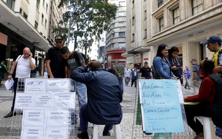 © Reuters. Pessoas observam lista de vagas de emprego no centro de São Paulo