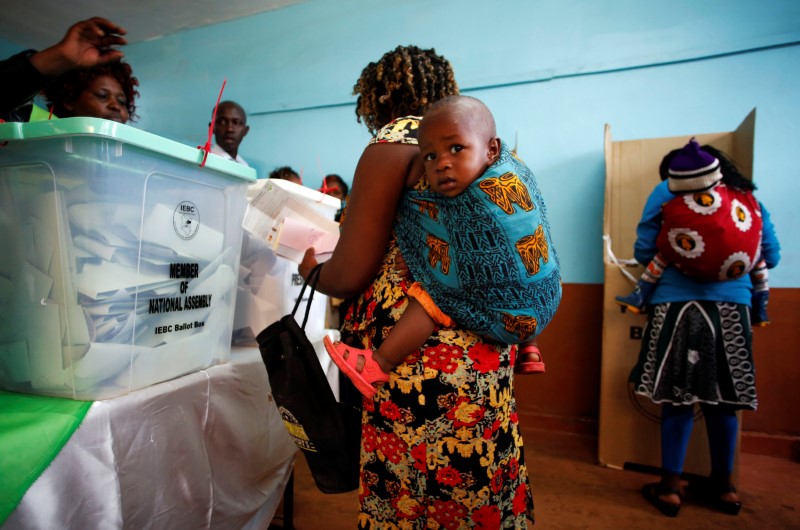 © Reuters. Mulher carregando bebê vota em seção eleitoral na cidade de Gatundu, no Quênia