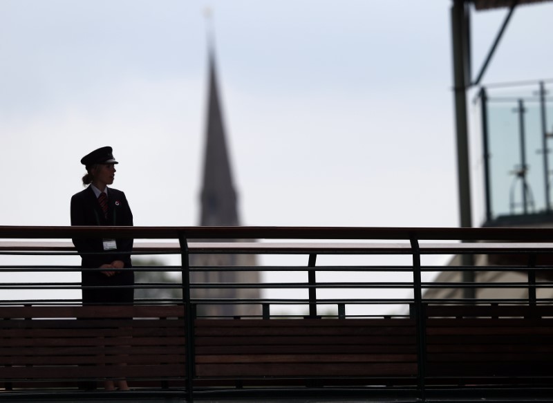 © Reuters. FILE PHOTO - A G4S security guard watches over some of the courts at the Wimbledon Tennis Championships, in London