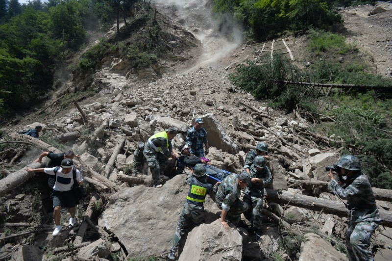 © Reuters. Policiais paramilitares chineses carregam sobrevivente após terremoto na região de Jiuzhaigou, na província de Sichuan