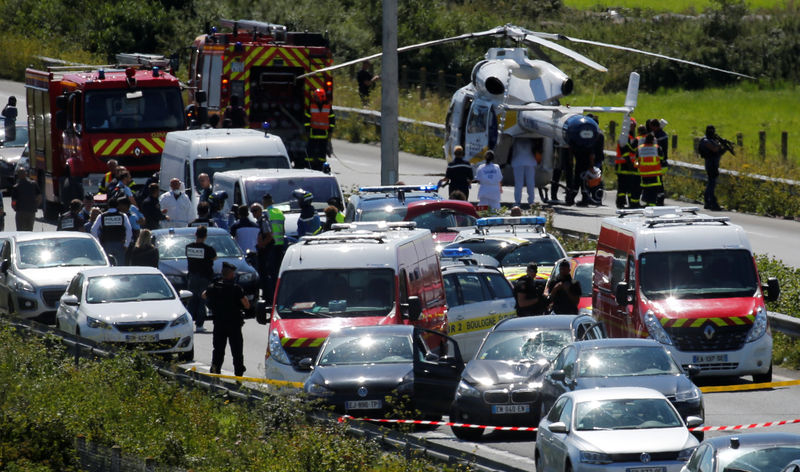 © Reuters. Police and rescue forces are seen on the scene where the man suspected of ramming a car into a group of soldiers on Wednesday in a Paris suburb has been shot and arrested on the A16 motorway