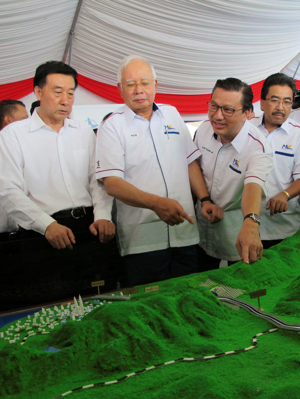 © Reuters. Malaysia's Prime Minister Najib Razak and Transport Minister Liow Tiong Lai look at a model of the East Coast Rail Line at Kuantan Bahang