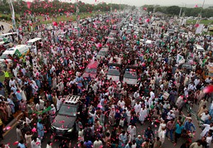 © Reuters. Supporters of former Pakistani Prime Minister Nawaz Sharif crowd around his car as his convoy enters RawalpindI