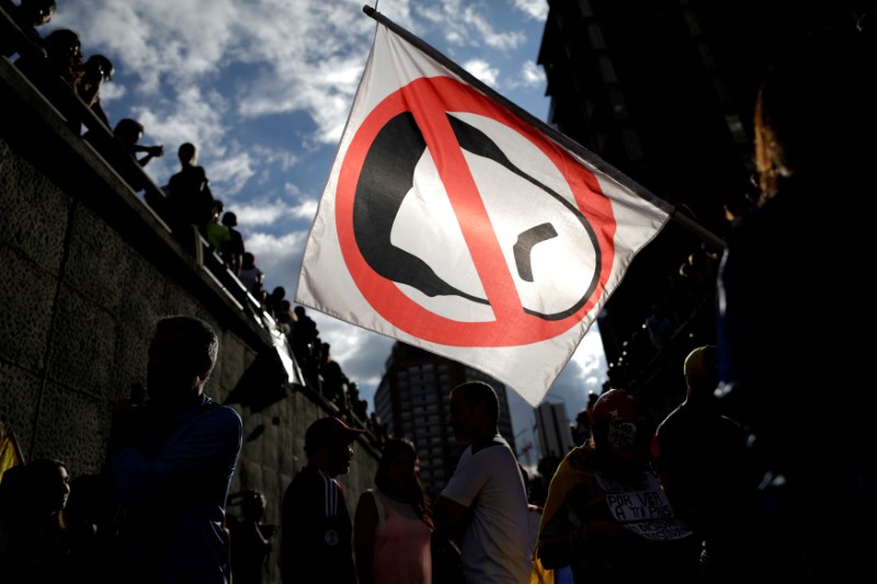 © Reuters. Manifestantes de oposição na Venezuela carregam bandeira com desenho do presidente Nicolás Maduro, durante protesto em Caracas