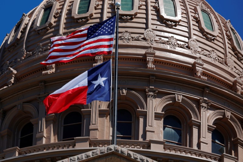 © Reuters. FILE PHOTO: The U.S flag and the Texas State flag fly over the Texas State Capitol in Austin