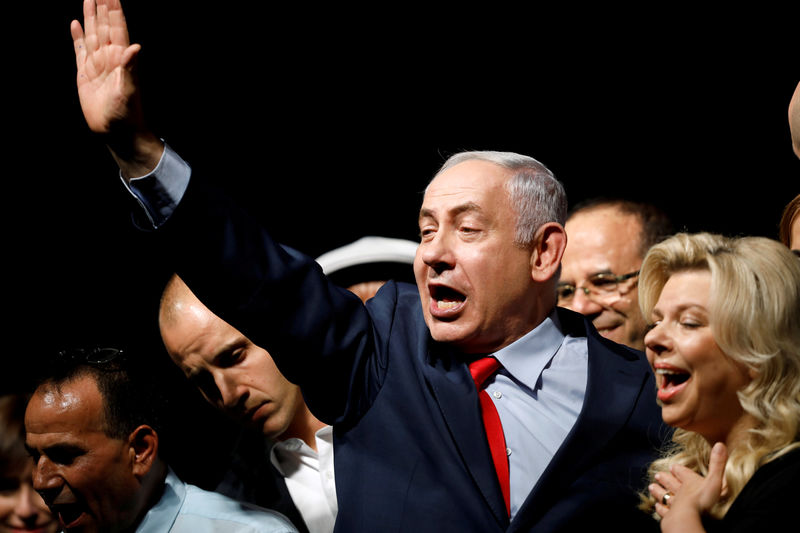 © Reuters. Israeli Prime Minister Benjamin Netanyahu (C) and his wife Sara react to his supporters during an event by his Likud Party in Tel Aviv