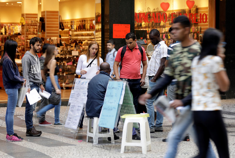 © Reuters. Pessoas olham para anúncio de vagas de emprego em rua no centro de São Paulo, Brasil