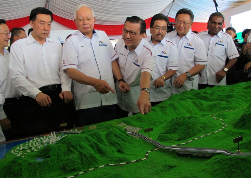 © Reuters. Malaysia's Prime Minister Najib Razak and Transport Minister Liow Tiong Lai look at a model of the East Coast Rail Line at Kuantan Bahang