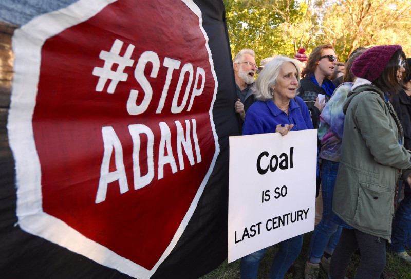 © Reuters. Protesters hold banners and signs during a demonstration against Indian company Adani Enterprises building one of the world's biggest coal mines in Australia outside the Indian High Commission in Canberra