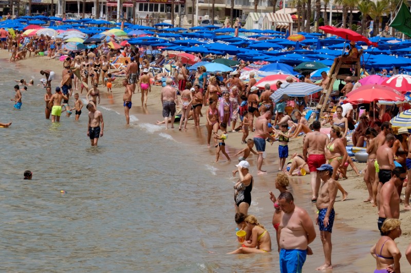 © Reuters. People enjoy the beach in the southeastern city of Benidorm