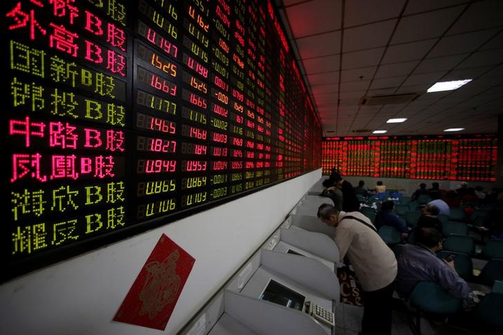 © Reuters. Инвесторы наблюдают за торгами в брокерской компании в Шанхае