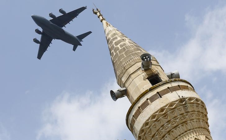 © Reuters. Aeronave norte-americana sobrevoa minarete após decolar da base aérea de Incirlik, em Adana, na Turquia