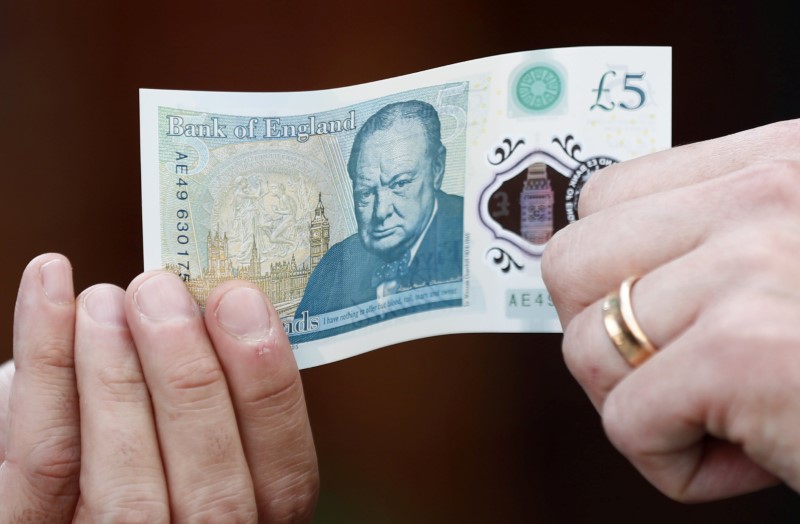 © Reuters. FILE PHOTO: Bank of England governor Carney poses with a new polymer five pound note at Whitecross Street Market in London