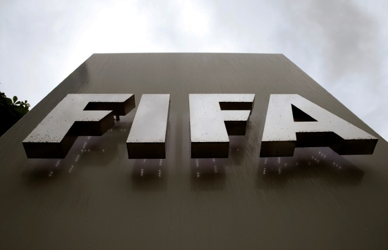 © Reuters. FILE PHOTO - Raindrops flow down on a logo in front of FIFA's headquarters in Zurich