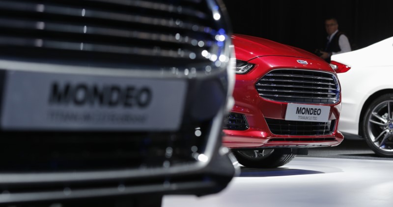 © Reuters. A visitor walks past new Ford Mondeo cars on display on media day at the Paris Mondial de l'Automobile