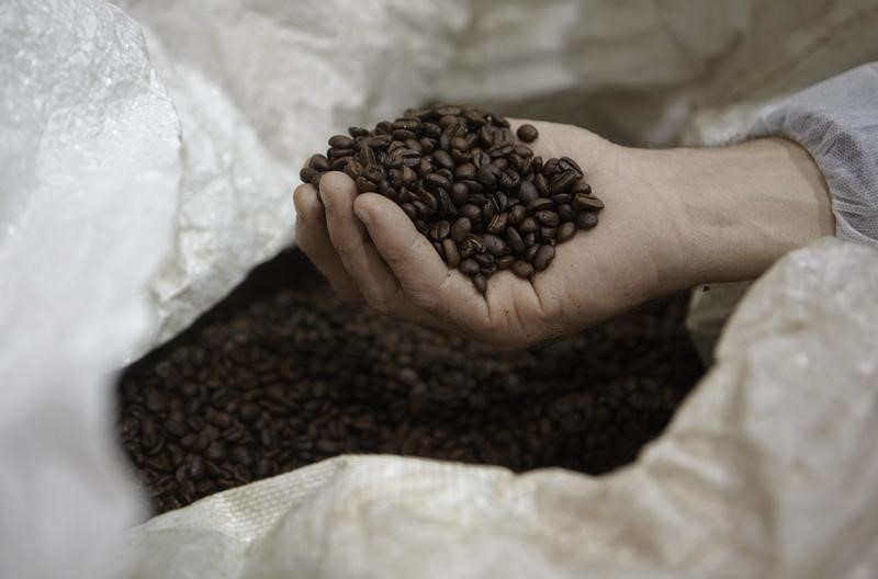 © Reuters. Homem segura grãos de café em Ville-la-Grand, na França