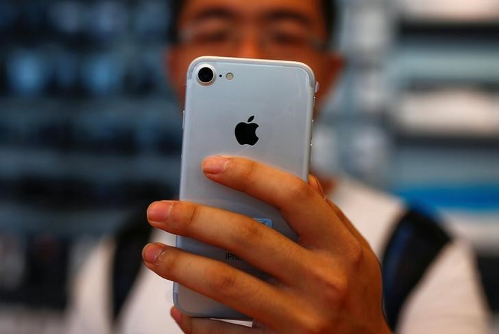 © Reuters. Homem segura seu iPhone 7 em loja da Apple em Pequim, China
