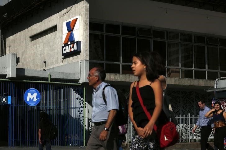 © Reuters. Pessoas circulam em frente de agência da Caixa no Rio de Janeiro