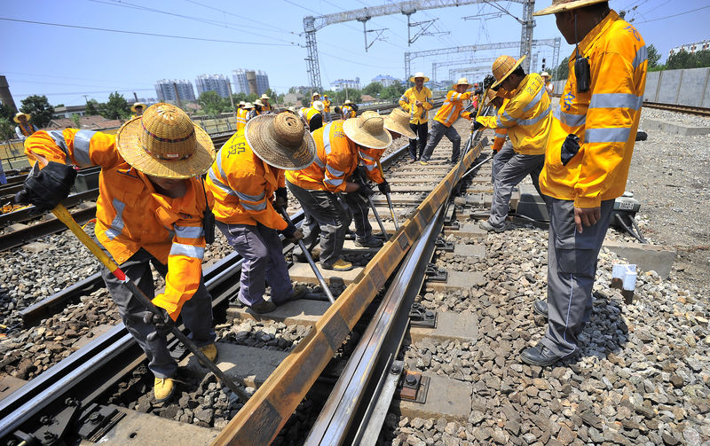 © Reuters. Workers replace railway tracks at a station in Jinan