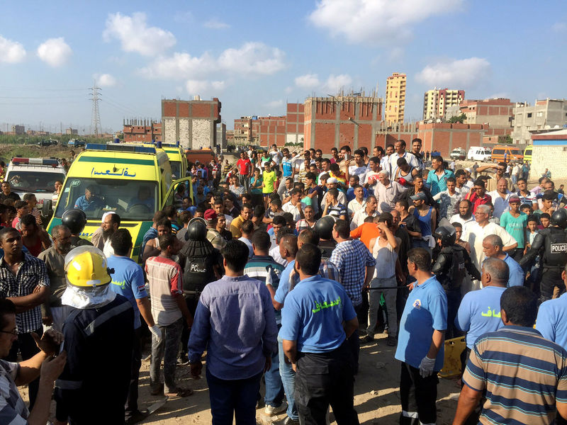 © Reuters. Egyptians and security personnel are seen at the site of a crash where two trains collided near the Khorshid station in Egypt's coastal city of Alexandria