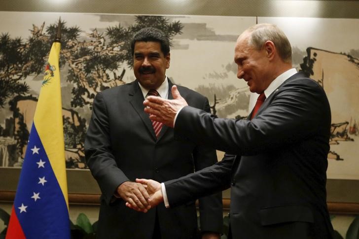 © Reuters. Президент России Владимир Путин жмет руку президенту Венесуэлы Николасу Мадуро во время встречи в Пекине
