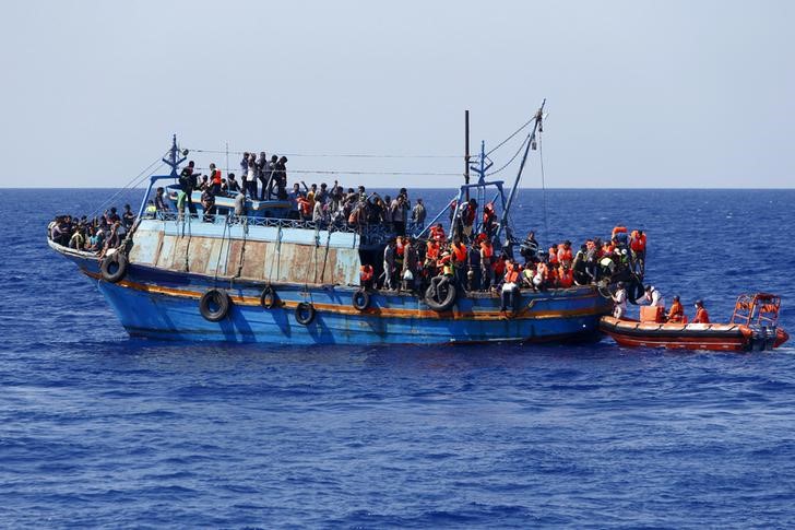 © Reuters. FILE PHOTO - Migrants on board an overloaded wooden boat are rescued some 10.5 miles off the coast of Libya