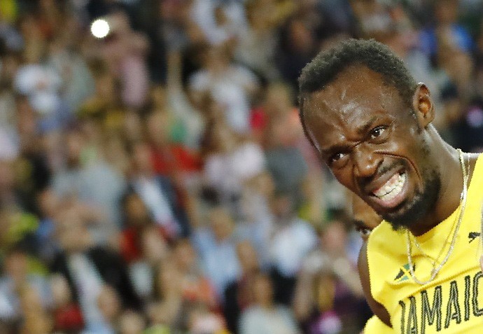 © Reuters. Usain Bolt de Jamaica reacciona después de sufrir una lesión
