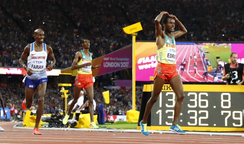 © Reuters. Muktar Edris de Etiopía y Mo Farah de Reino Unido reaccionan después de cruzar la línea de meta
