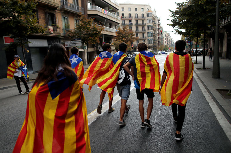 © Reuters. Jovens enrolados em bandeiras separatistas da Catalunha caminham durante protesto em Barcelona