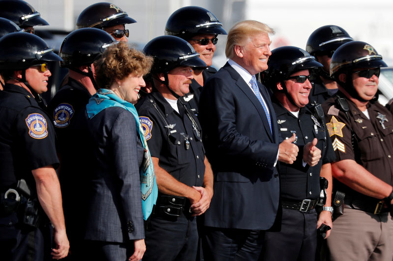 © Reuters. U.S. President Donald Trump poses for a photo with motorcycle police officers before departing aboard Air Force One to return to Washington from Indianapolis International Airport in Indianapolis