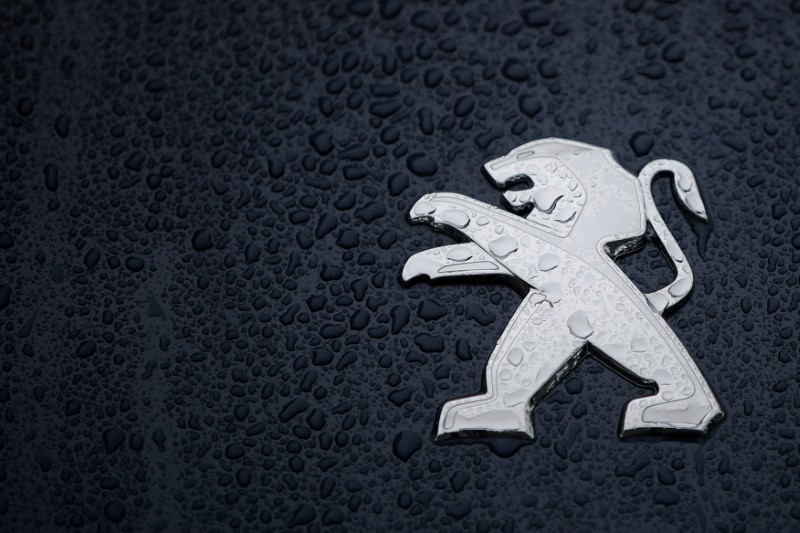 © Reuters. Raindrops cover the logo of French car manufacturer Peugeot on a automobile seen in Nantes