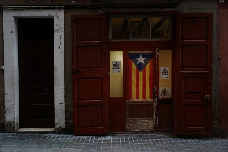 © Reuters. An Estelada (Catalan separatist flag) hangs from the door of an establishment in Barcelona