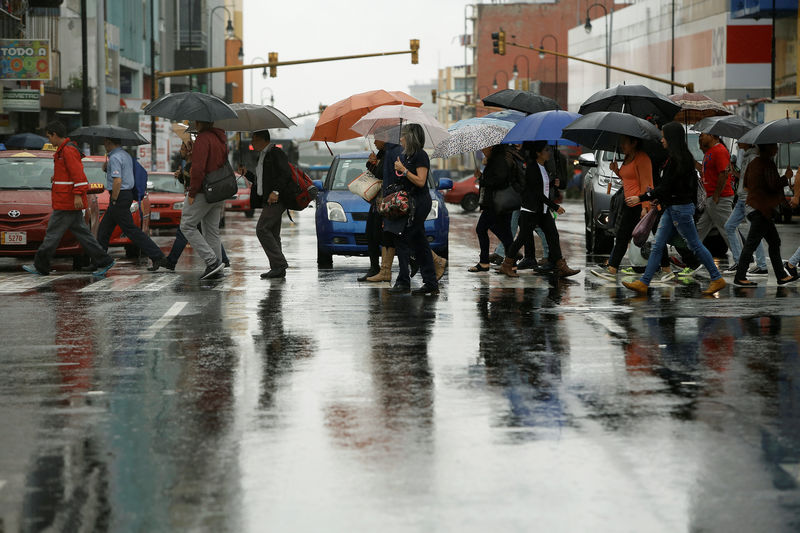 © Reuters. People walk on the main street of the city of San Jose, during heavy rains by Tropical Storm Nate, Costa Rica