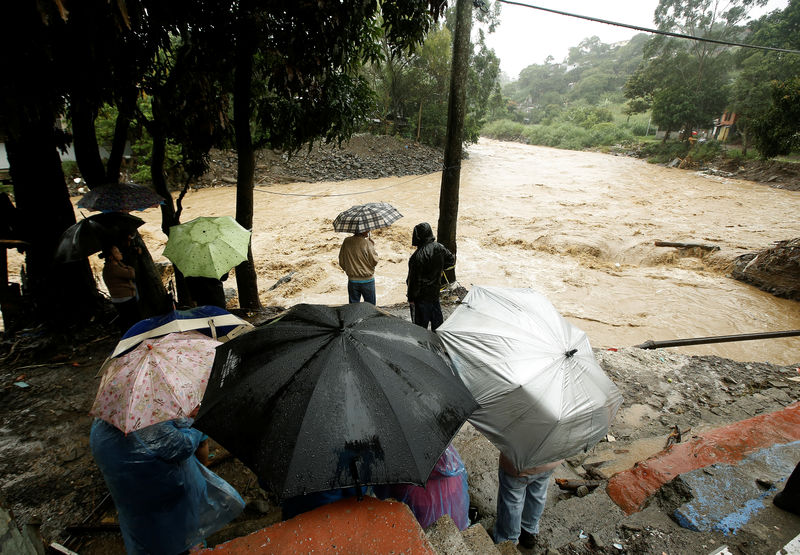 © Reuters. Pessoas observam cheia do rio Tiribi após fortes chuvas em San José, na Costa Rica