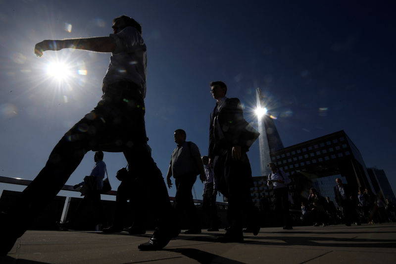 © Reuters. FILE PHOTO: Workers cross London Bridge with the Shard skyscraper seen behind during the morning rush hour in London, Britain