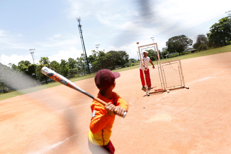 © Reuters. A boy plays baseball with his father at the recreation and sport facilities of General Motors in Valencia