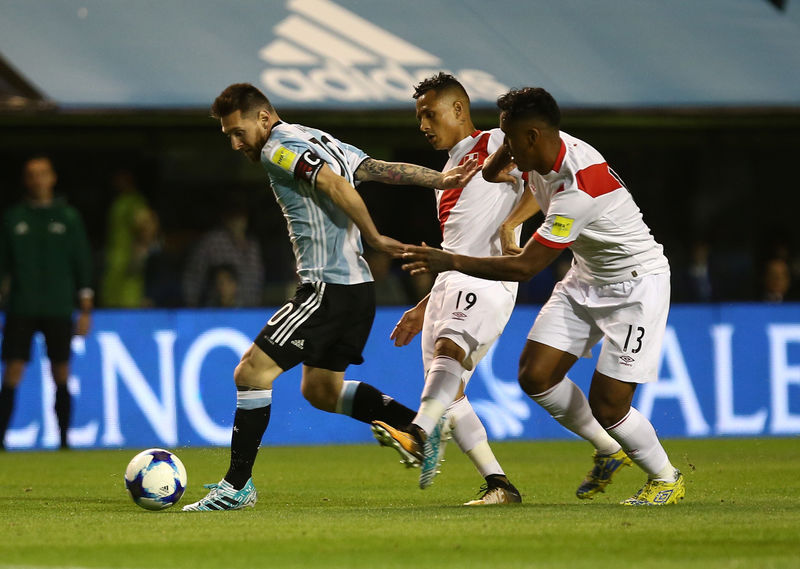 © Reuters. Foto del jueves del delantero argentino Lionel Messi en acción ante los jugadores peruanos Yoshimar Yotun y Renato Tapia