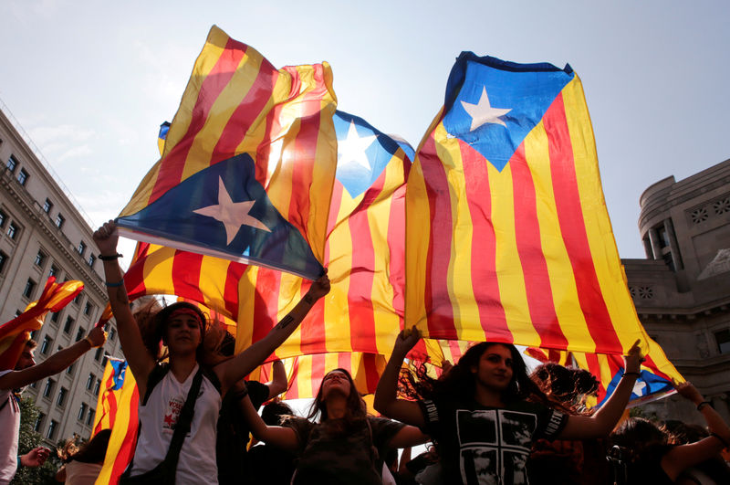 © Reuters. People hold on to Catalan separatist flags on top of an air vent during a demonstration two days after the banned independence referendum in Barcelona