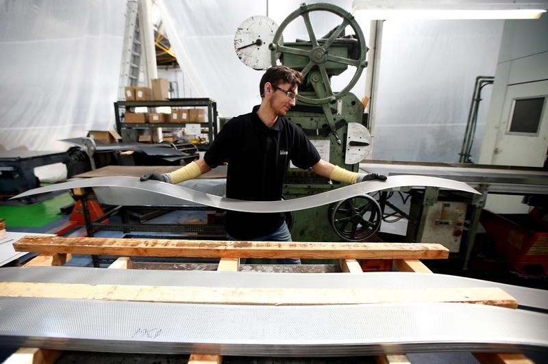 © Reuters. A worker at perforating company Bion carries a piece of perforated metal at the factory in Reading